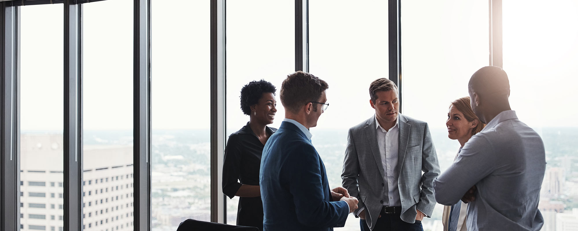 Group of business people standing in office having discussion
